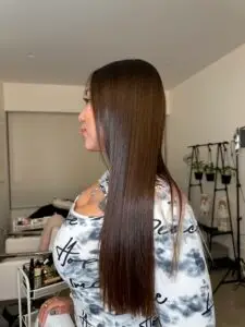 Resultado de alisado orgánico sin formol en cabello largo y oscuro, mostrando brillo espejo.